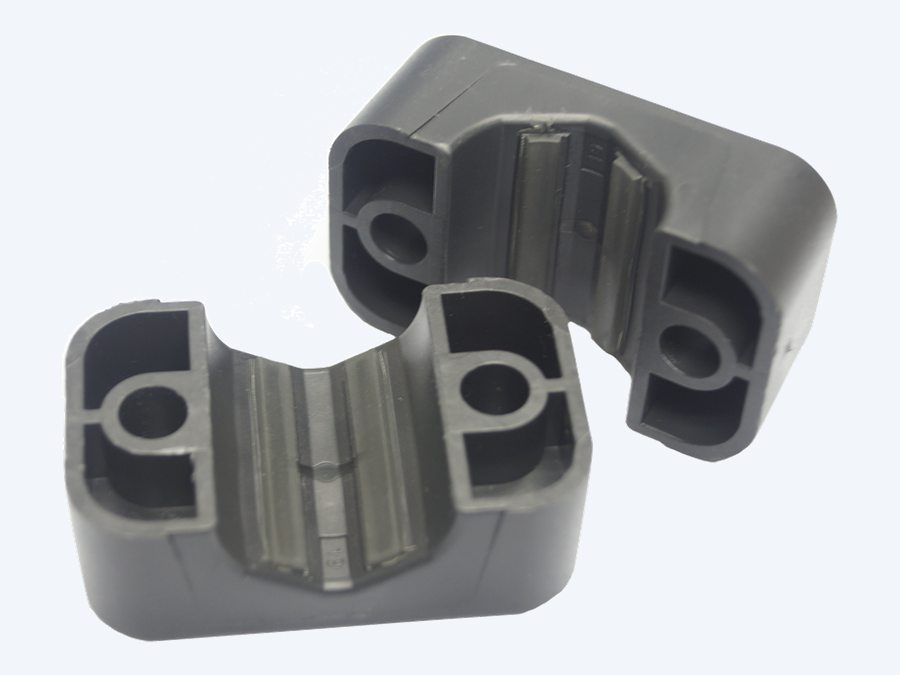 Two STAUFF ACT clamp halves open, showing the integrated ribbed elastomer strips running along the bore