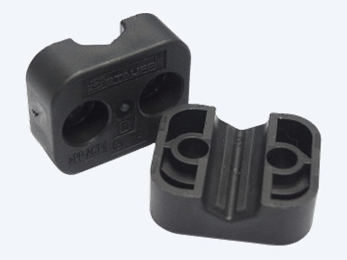 STAUFF ACT twin clamp halves from the side, showing the moulded markings and the bolt lugs