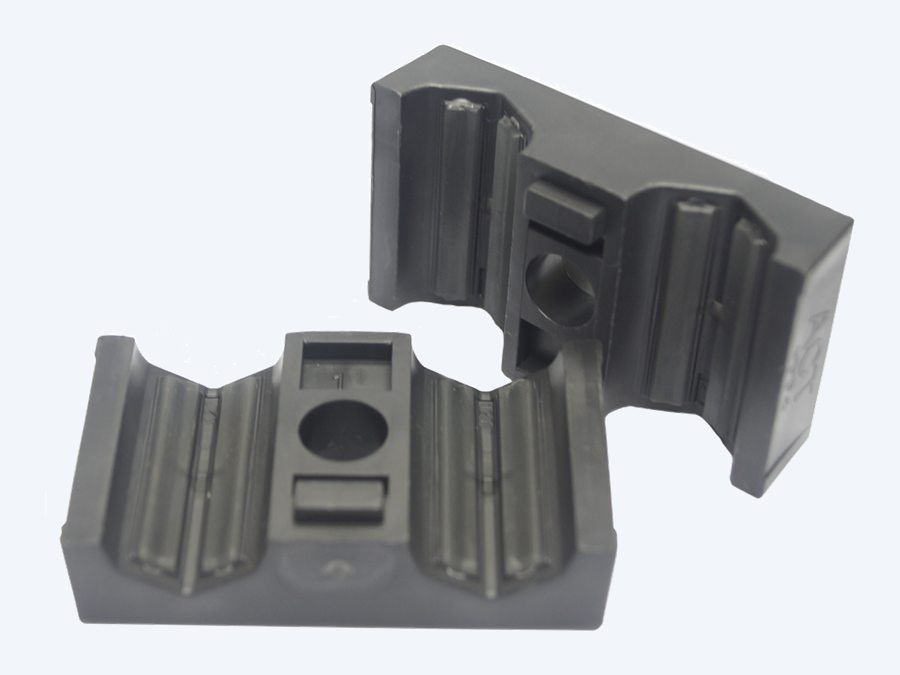 STAUFF ACT clamp halves with a weld plate, seen from an angle that shows the underside and the bolt lugs