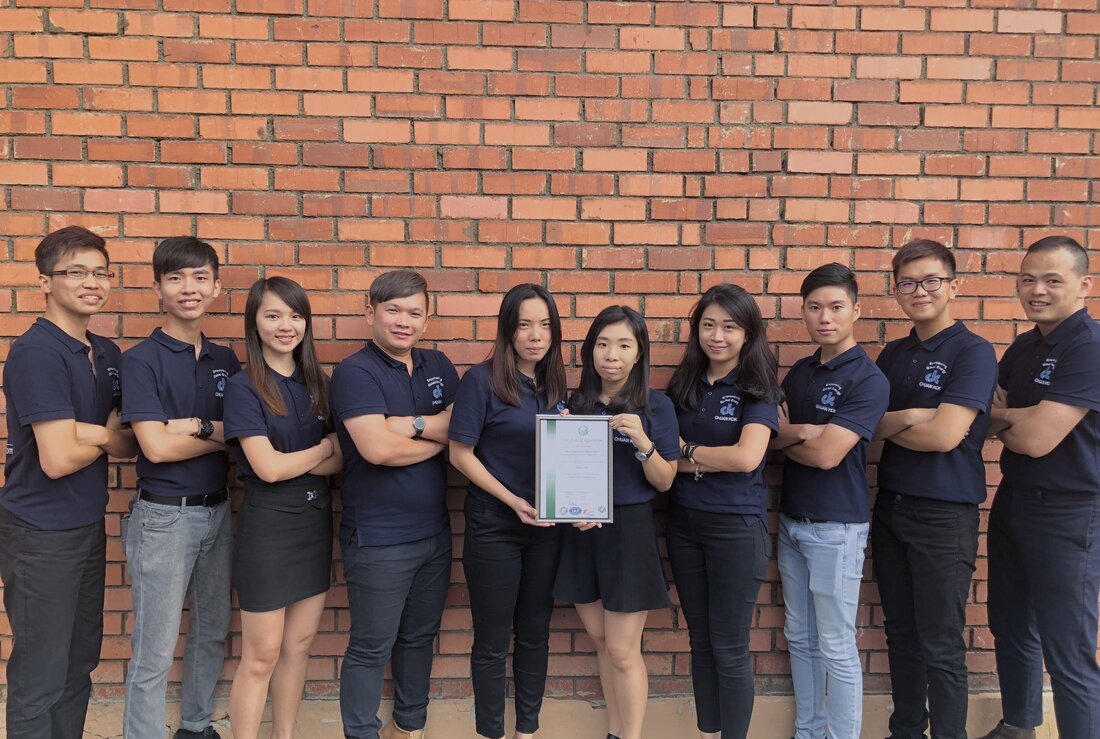 The team holding a framed certification certificate