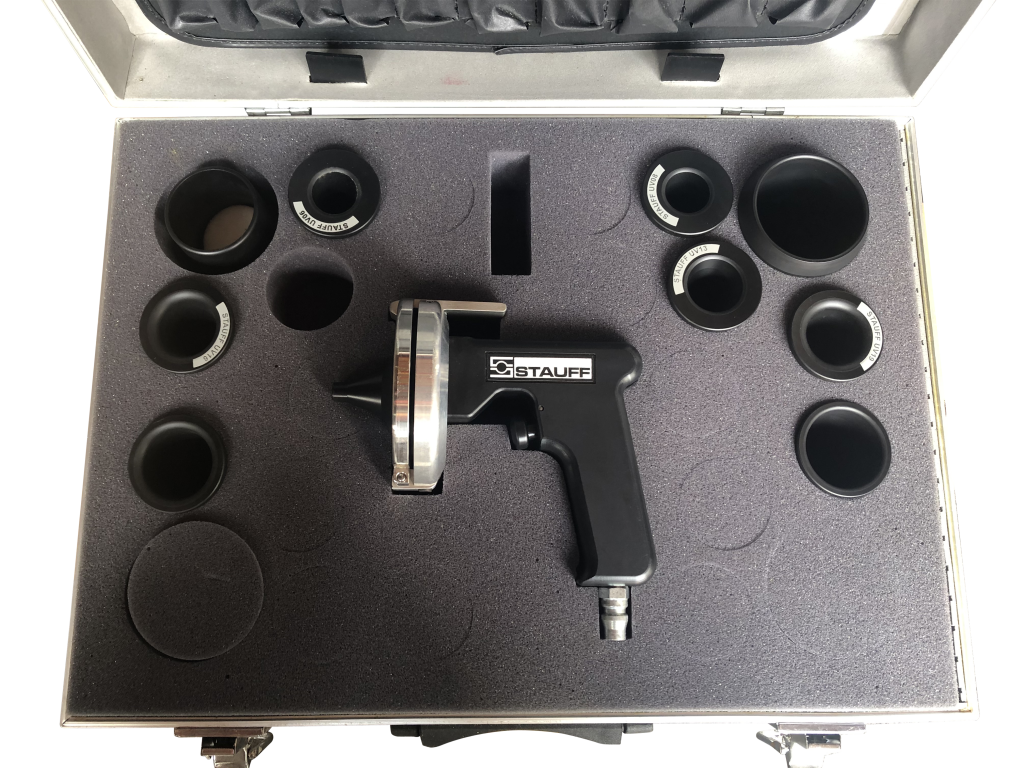 STAUFF SC-10UV-K kit laid out in its foam-lined case, the launcher surrounded by ten universal nozzles